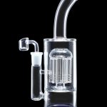 Clear glass dab rig with percolator and accessories on a black background.