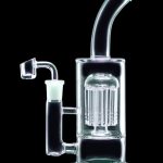 Clear glass water pipe (rig) with intricate perc filtration, featuring a green base and quartz nail.