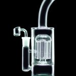 Clear glass water pipe with intricate percolator and attached glass bowl, isolated on black.