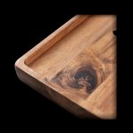 Wooden rolling tray with a natural knot detail, angled on a black background.