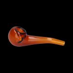 Amber glass pipe with a curved stem, isolated on a black background.