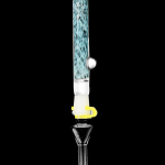 A vibrant glass oil rig with teal and white swirls, featuring a perc for filtration and a quartz nail for concentrates.