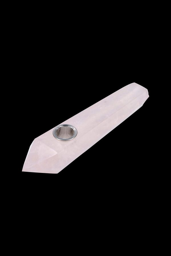 Rose quartz crystal pipe with a metal bowl, isolated on a black background.