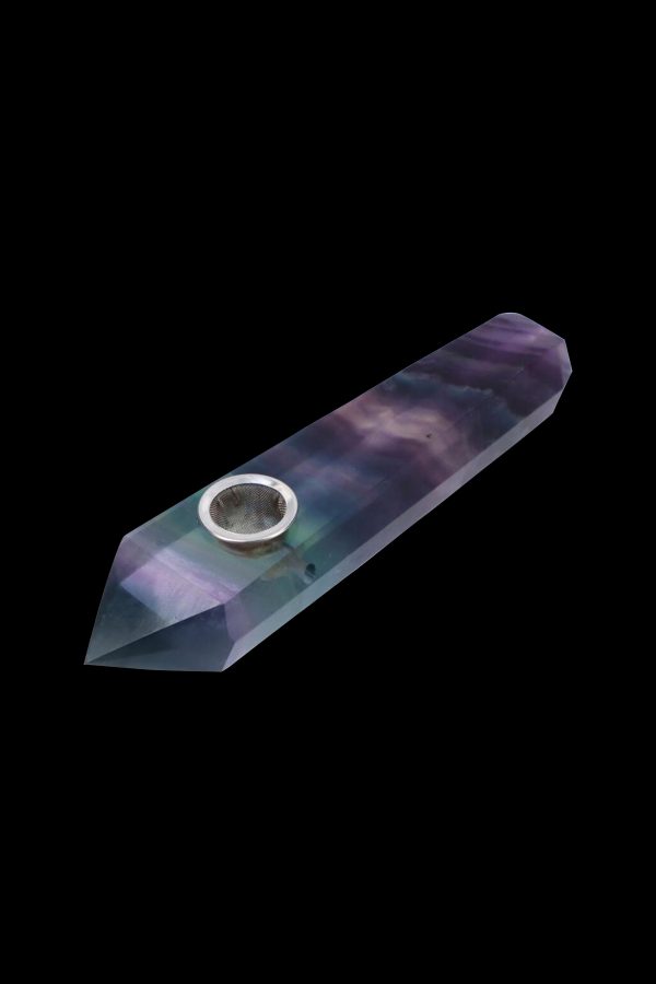 Iridescent crystal pipe against a black background.
