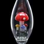 A side view of the Smoke Cartel Egg with Mushroom Perc Nectar Collector shows colorful mushroom-shaped percolators inside the clear glass egg-shaped body.