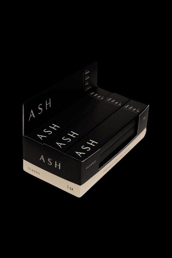 Stacked black boxes labeled "ASH" and "Classic," likely containing cannabis pre-rolls or accessories.