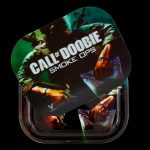 A clear plastic rolling tray displaying a design inspired by the video game “Call of Duty,” featuring a soldier, cannabis leaves, and the text “CALL OF DOOBIE SMOKE OPS.”