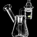 Front view of the Compact Travel Etched Dab Rig Set, a small, clear glass rig with detailed etched designs and a visible bowl.