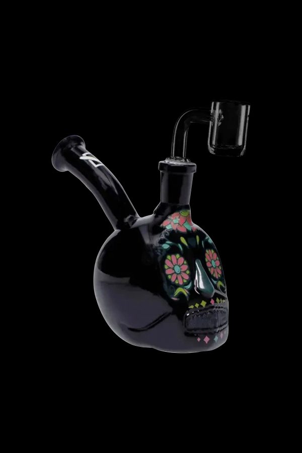 Black glass water pipe shaped like a sugar skull with colorful floral details, accompanied by a glass downstem.