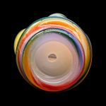 A colorful glass pipe against a black background.