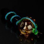 Glass cannabis pipe with colorful swirls against a black background.