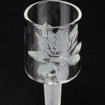Etched glass cannabis bowl with floral design, studio shot.