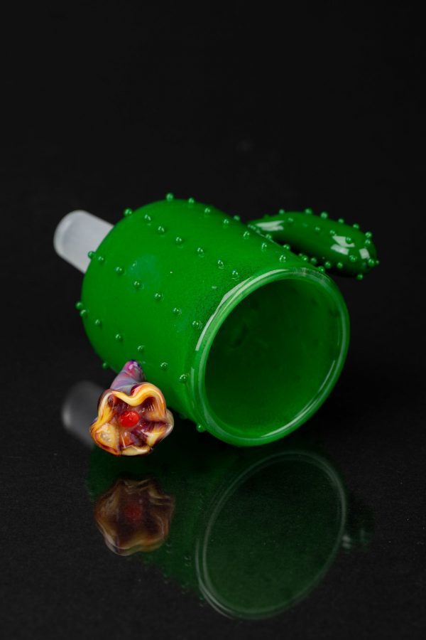 Green glass cactus-shaped bubbler with a colorful glass mouthpiece, isolated on a black background.