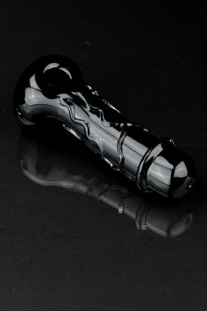 Black glass cannabis pipe with swirling design, reflecting on a dark surface.