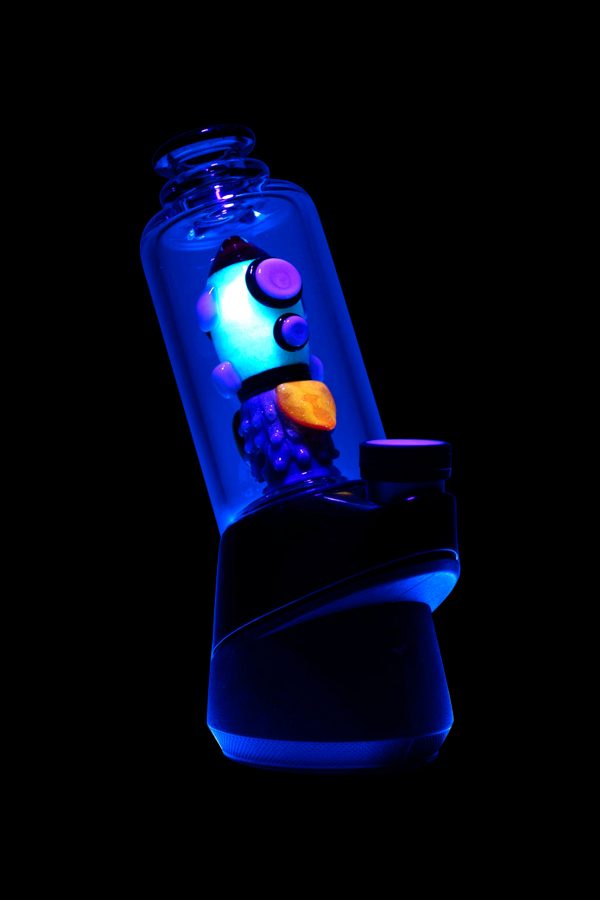 Glowing electric dab rig with cannabis concentrate visible inside, set against a black background.