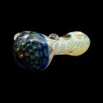 Hand-blown glass pipe with iridescent green and cream swirls against a black background.