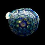 Iridescent glass cannabis water pipe against a black background.