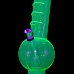 Glowing green glass water pipe (bong) with purple accents on a black background.