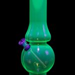 Glowing green glass water pipe (bong) against a black background.