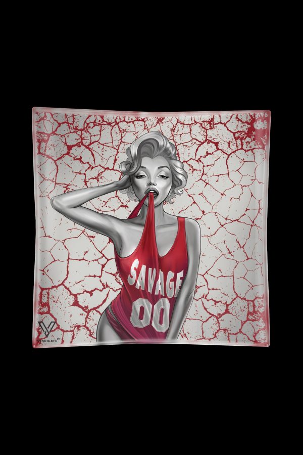 A glass ashtray featuring a stylized black and white illustration of Marilyn Monroe in a red tank top with "SAVAGE" printed on it, set against a cracked red and white background.