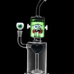 Glass water pipe shaped like Frankenstein's monster with a clear base and green head, isolated on a black background.