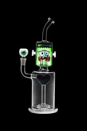 Glass water pipe shaped like Frankenstein's monster with a clear base and green head, isolated on a black background.