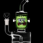 Green glass water pipe shaped like Frankenstein's monster with detachable glass bowl.