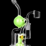 A studio shot of the Diamond Glass Buoy Recycler Rig, showing the clear glass recycler with a rounded base and angled mouthpiece.