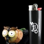 A colorful glass owl figurine sits beside a black lighter branded with ""Smoke Cartel"" and its website address."