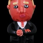 A glass sculpture of Donald Trump wearing a suit, likely a novelty cannabis accessory.