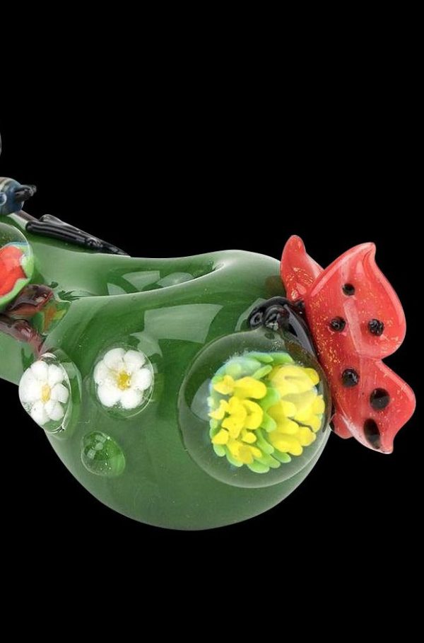 A side view of the Empire Glassworks Spoon Pipe - Garden Critters, featuring sculpted flowers and insects on green glass.
