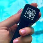 Hand holding a black Jane West cannabis accessory, likely a pipe or one-hitter, with branded logo.