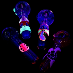 Neon-lit glass pipes with colorful, whimsical designs against a black background.