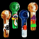Four colorful glass smoking pipes decorated with whimsical designs – a skull, an eye, a ladybug, and mushrooms – against a black background.