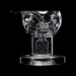 Clear glass dab rig with intricate floral detailing, isolated on a black background.