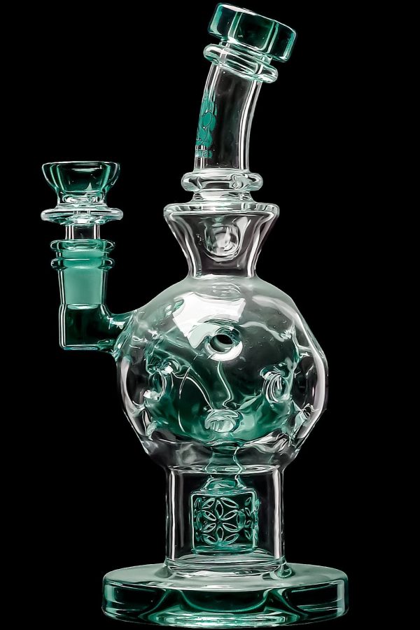 A clear glass water pipe (bong) with green accents and sculpted details, isolated on a black background.