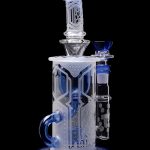 Clear glass water pipe (bong) with blue accents and intricate geometric patterns, studio shot on black background.
