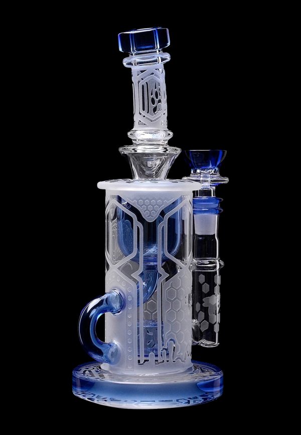 Clear glass water pipe (bong) with blue accents and intricate geometric patterns, studio shot on black background.