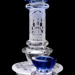 Intricate glass dab rig with blue accents, featuring a honeycomb perc and quartz banger.