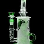 Glowing green glass water pipe (rig) with intricate sculpted designs.