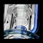 Close-up of a glass bong with a honeycomb diffuser and blue accents.