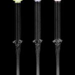 Three glass cannabis water pipes with colored accents against a black background.