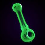 Glowing green glass pipe against a black background.