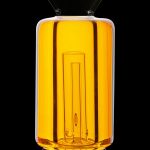 Golden glass bubbler with vertical ridges, isolated on a black background.