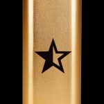 Gold cannabis storage tube with a black star emblem.