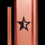Copper-colored one-hitter pipe with a black star logo and a detachable mouthpiece.
