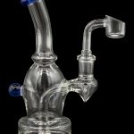 Clear glass dab rig with a bent neck and quartz banger, isolated on a black background.