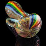 A vibrant, angled view of the Heavy Cane Worked Rainbow Spoon – Rainbow Mega Pipe, showcasing its colorful, sculpted glass design.
