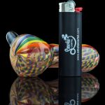 A vibrant close-up of the Heavy Cane Worked Rainbow Spoon - Rainbow Mega Pipe, displaying its colorful, swirling glasswork.
