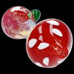 Red and white spotted glass mushroom-shaped cannabis pipe against a black background.